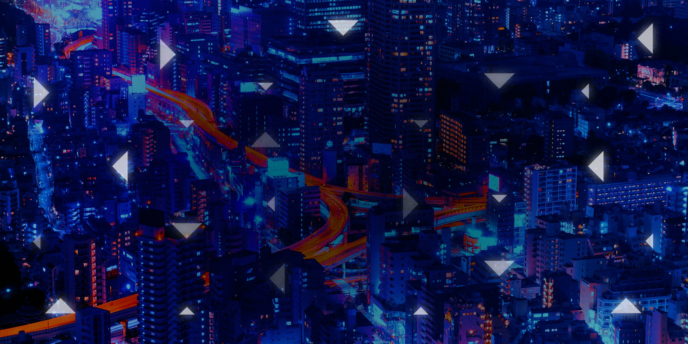 Aerial view of city with streaks of light left by bustling traffic, overlaid with a sparse pattern of triangles