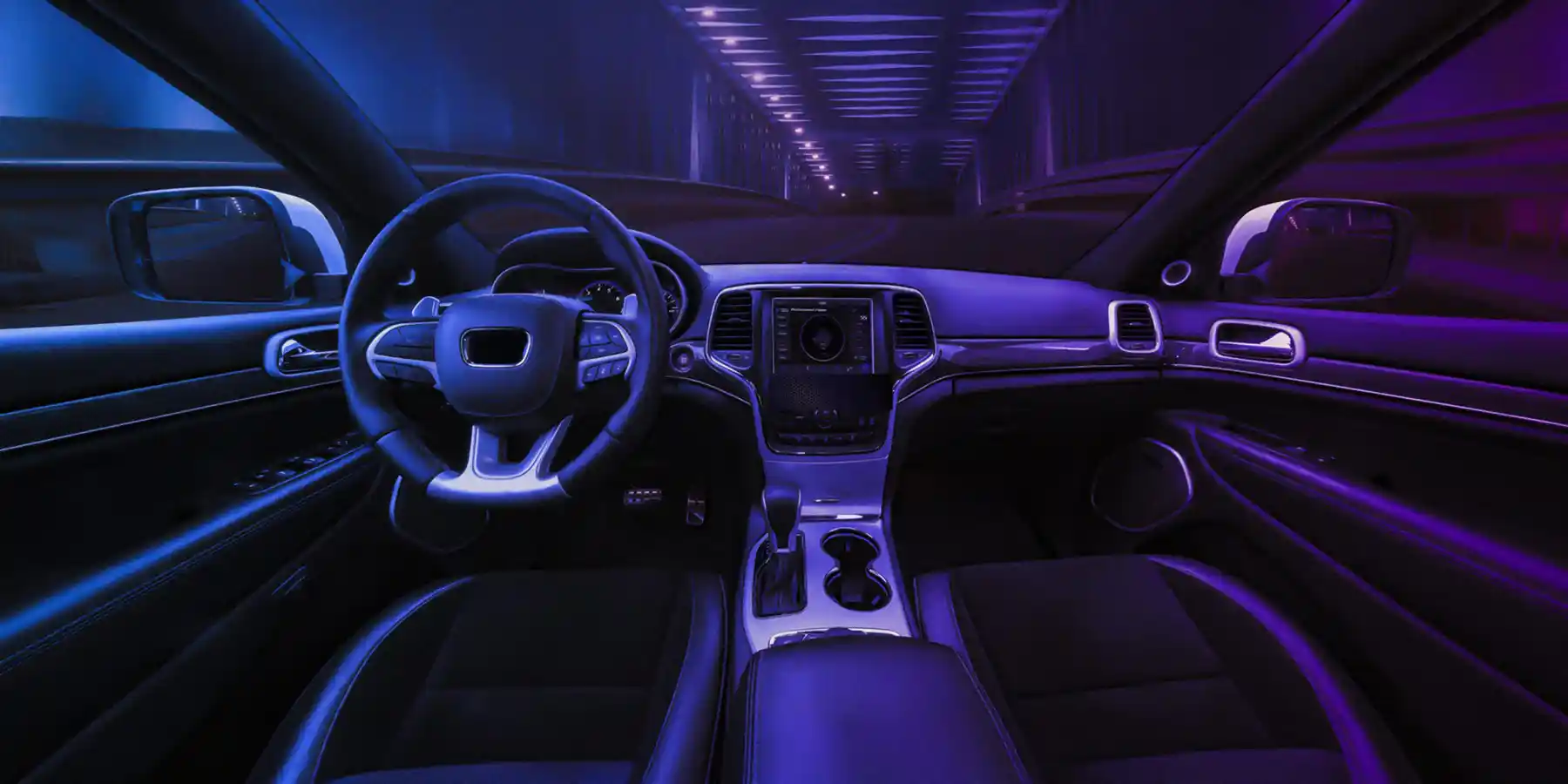 Interior of a car, including steering wheel and dashboard, from the driver’s perspective
