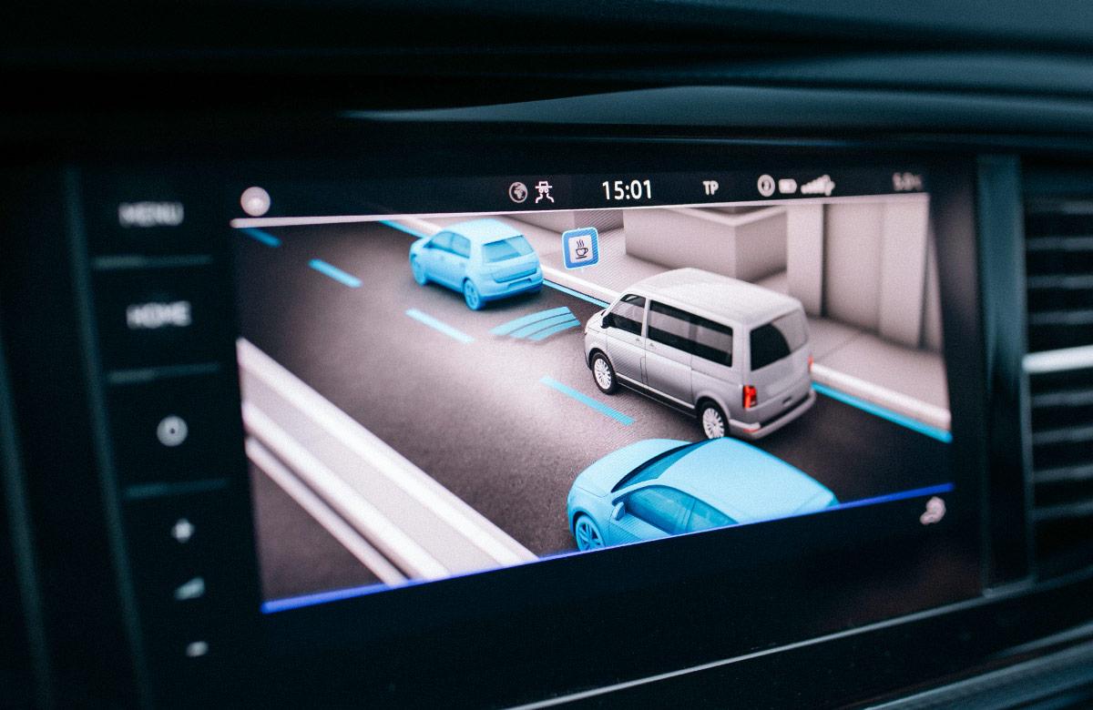 Photograph of a vehicle’s in-cabin screen display with parking assistance interface