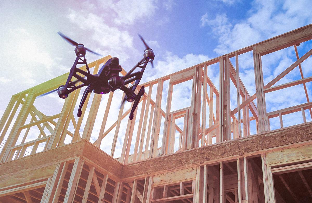 Black drone quadcopter with camera flying over residential construction home