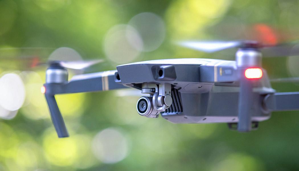 Drone with blurred propellers and video camera flying in the air