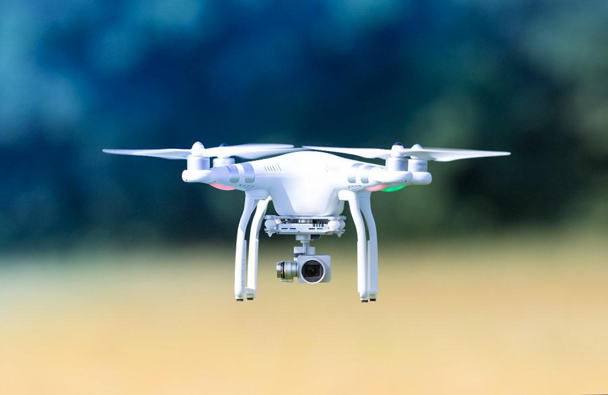 Drone with blurred propellers and video camera flying in the air