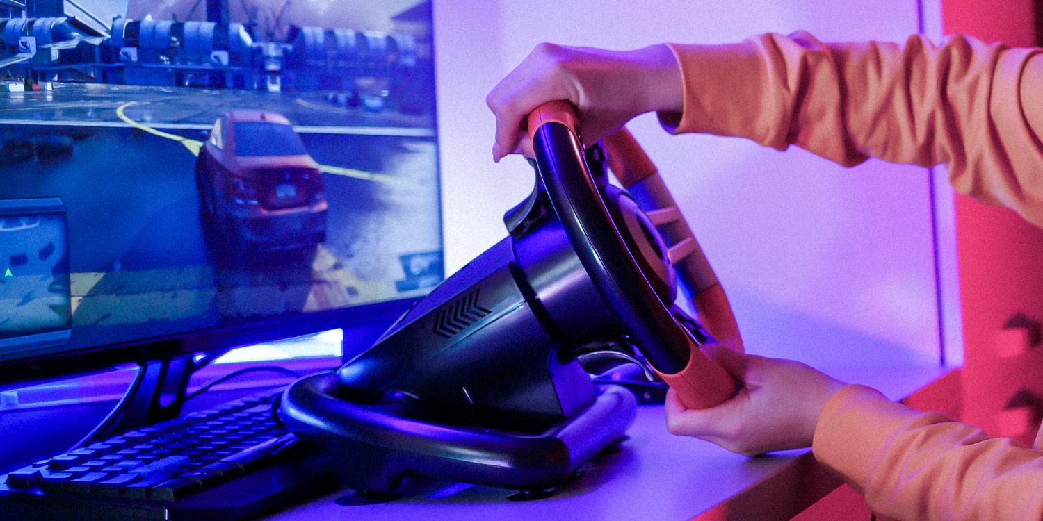 Close-up photograph of two hands turning a gaming steering wheel