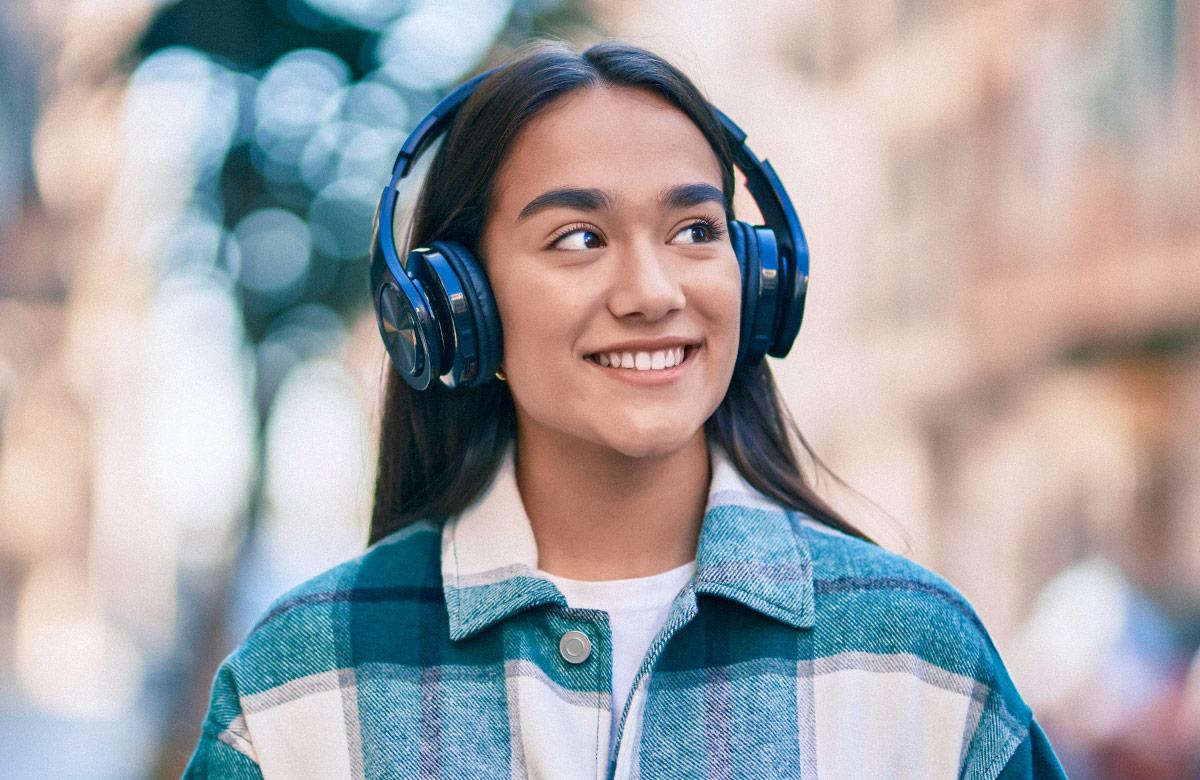 Girl smiling and wearing over-ear headphones