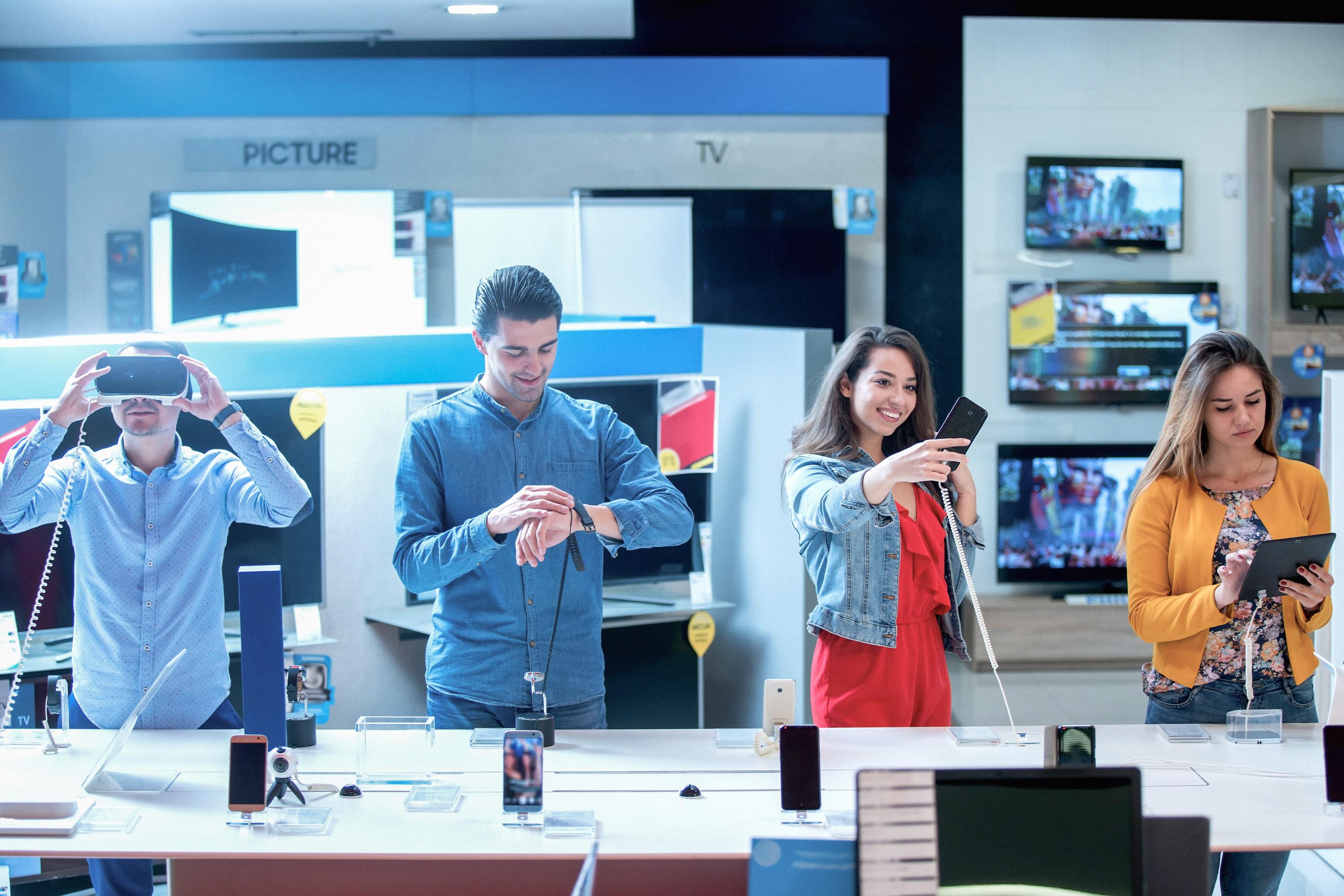 Photo of customers testing products inside a consumer electronics store