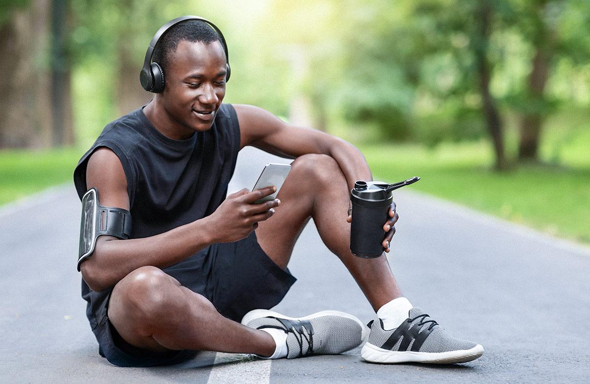 Man resting on path at public park, using phone