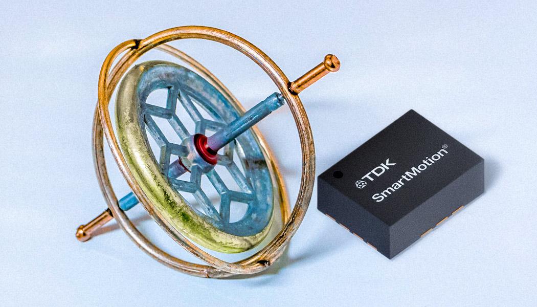 An enlarged TDK microchip next to a classic gyroscope