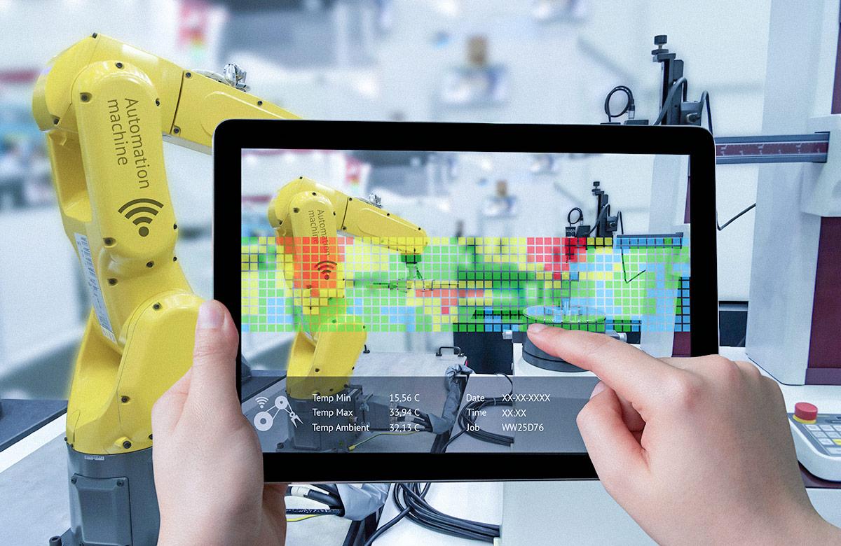 Photo of a pair of hands holding a tablet displaying an augmented reality app that’s focused on a robotic arm