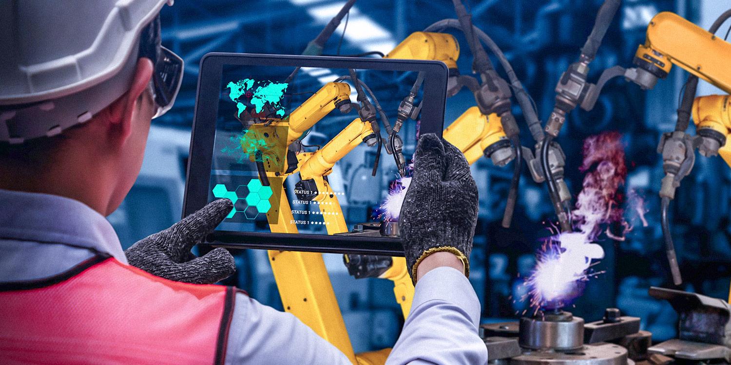 Photograph of industrial worker in a factory holding up a tablet with augmented reality technology