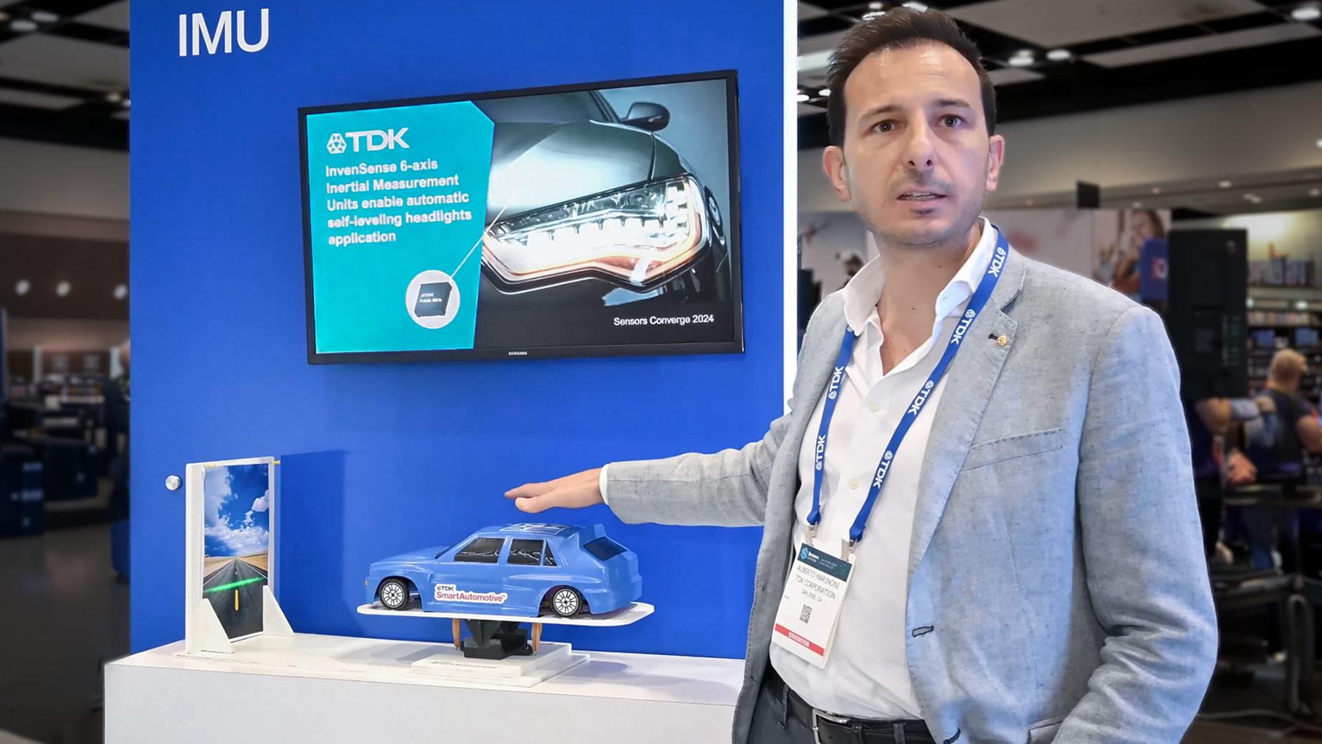 Photo of man at a trade show standing in front of a demo kiosk with automotive-related messaging