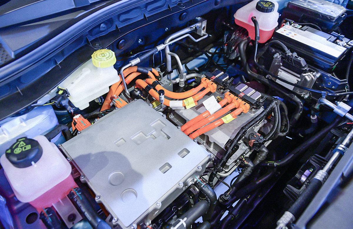 Close-up of electric car engine showing vehicle battery and coolant containers