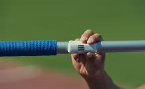 A hand holds a javelin that is equipped with a TDK IMU sensor for inertial motion tracking