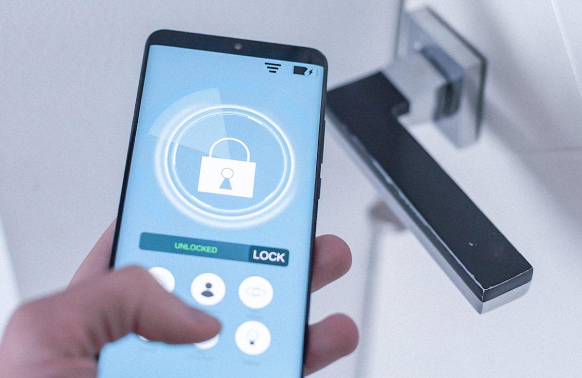 Hand holding a smartphone that’s displaying a smart home application