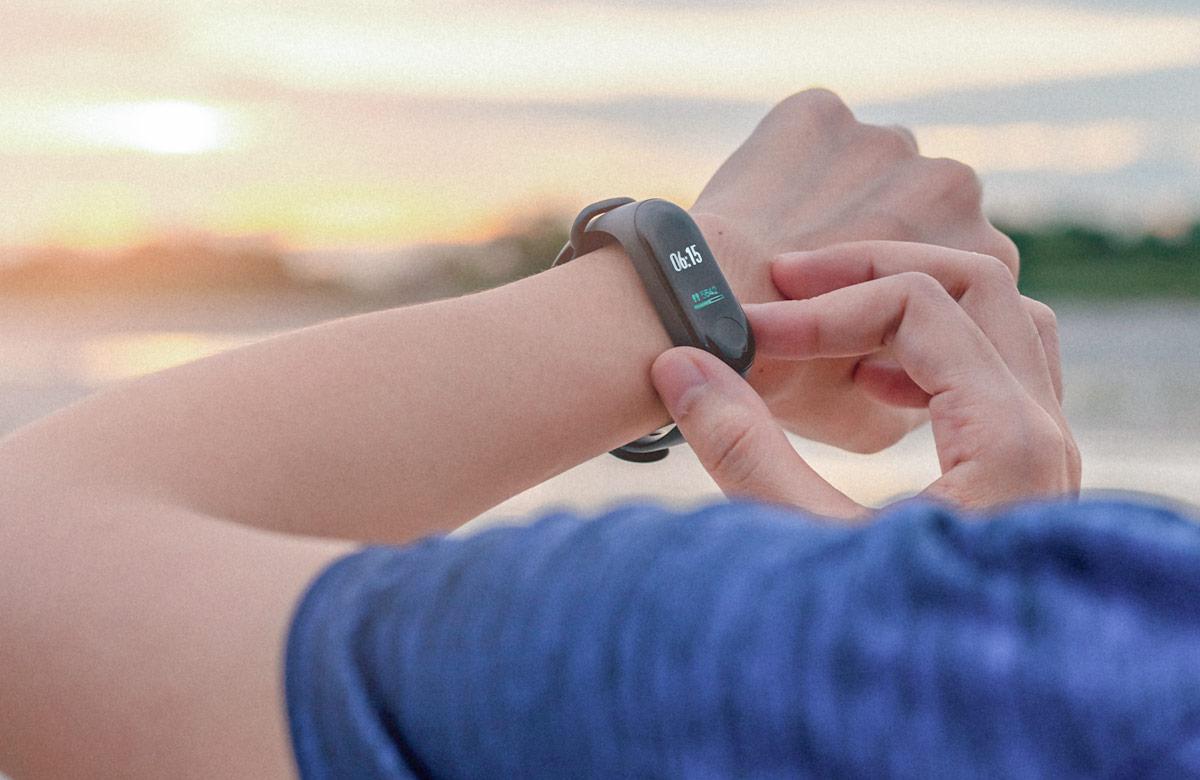 Person standing on a beach and interacting with their smart watch