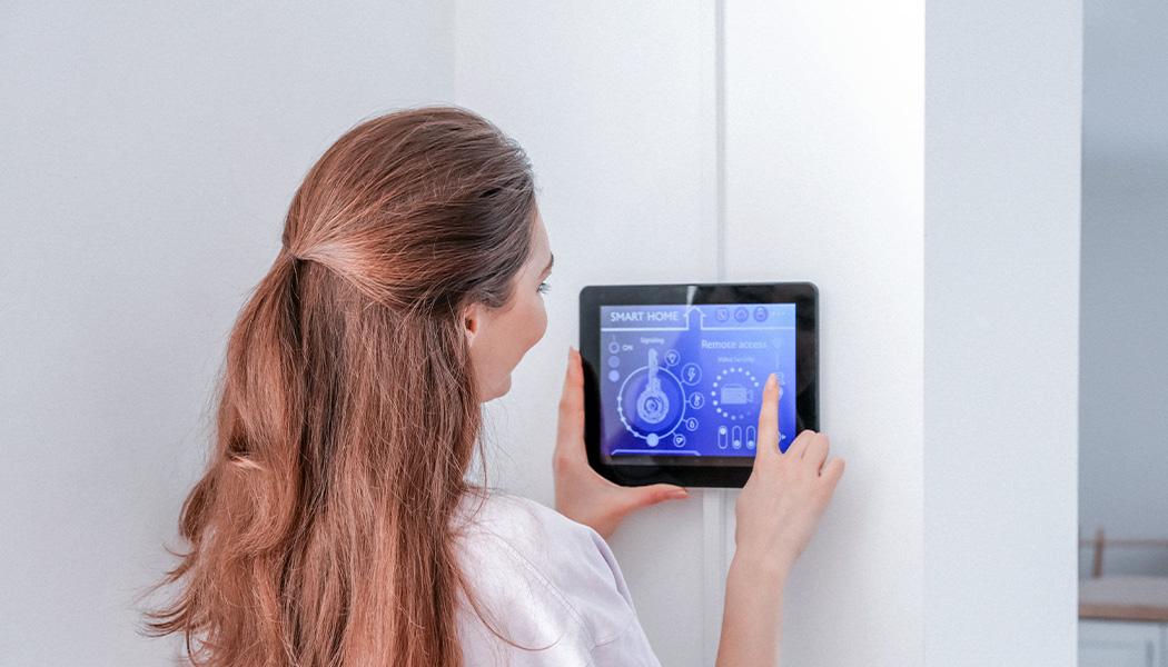 Woman using smart home security system control panel